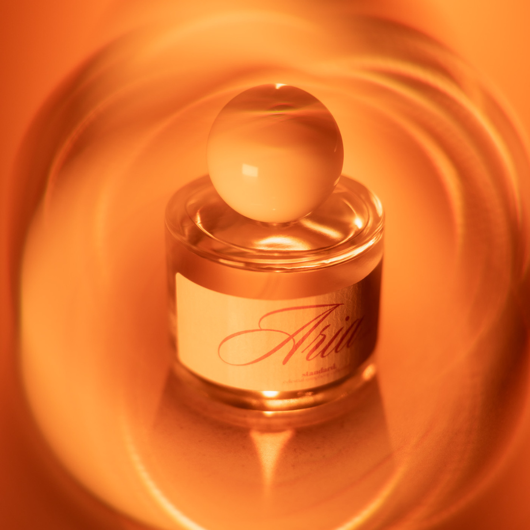 Standard Beauty Aria Eau de Parfum bottle on an amber background